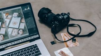 camera with memory card next to laptop showing photo editing